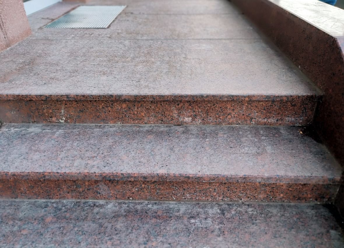 Laiptai iš deginto granito ir autentiška, atkartojanti pastato cokolį sienelė puošia Gedimino pr. 64, Vilniuje esantį pastatą